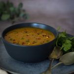 Masala Dal in a black bowl with spoons on the right side