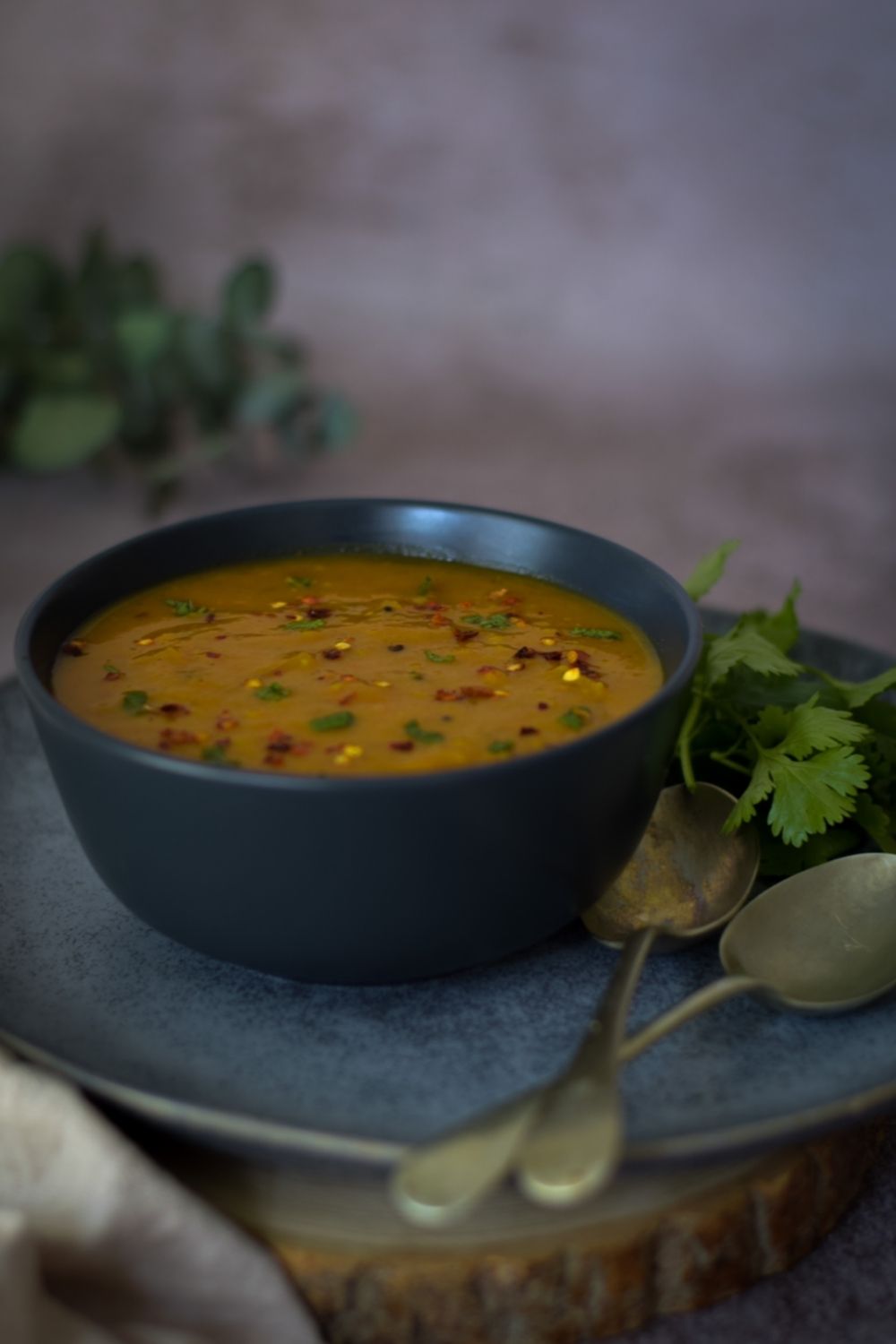 Masala Dal in a black bowl with spoons on the right side