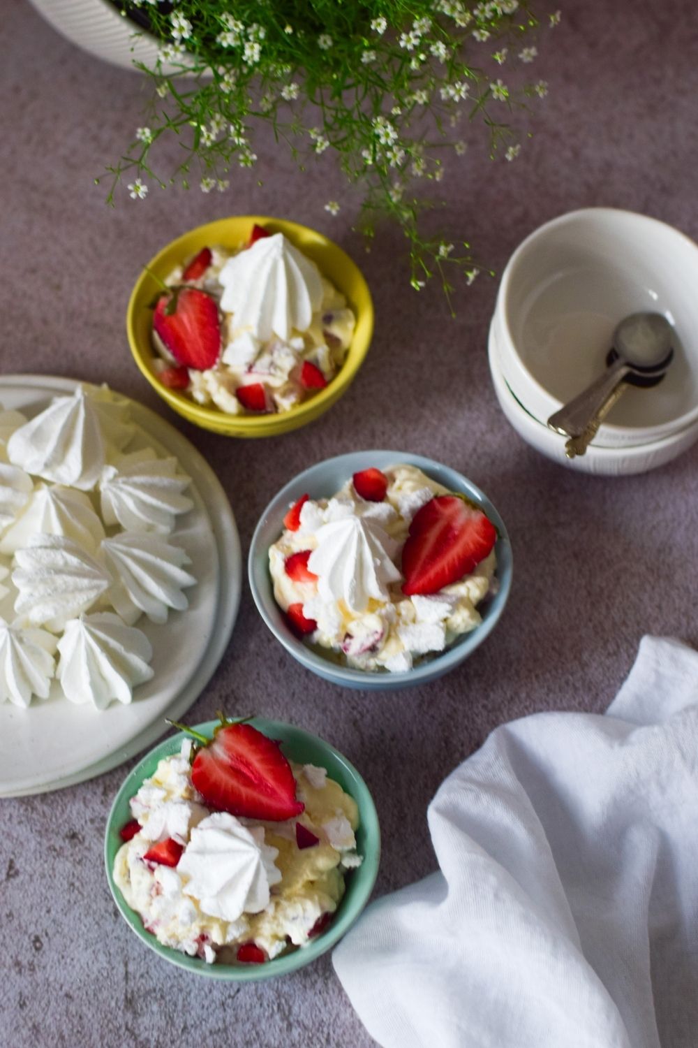 Strawberry Eton Mess in 3 bowls with meringues on left 