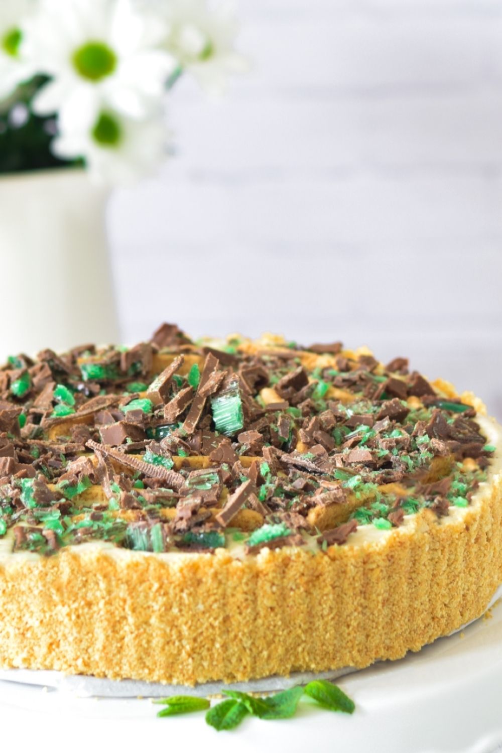 Peppermint Tart on a white platter with flowers on the left