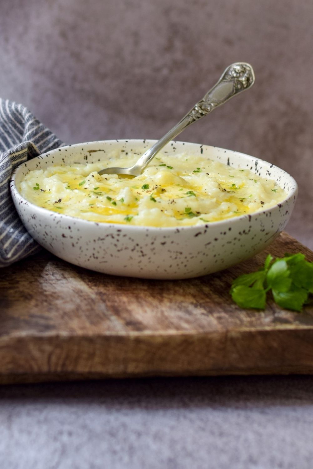 Creamy Garlic Mashed Potatoes in a white bowl with a spoon