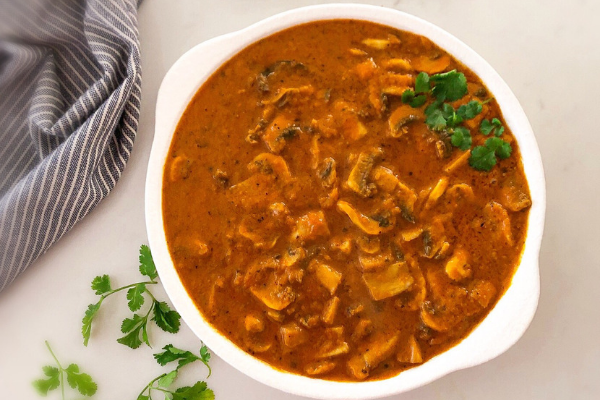 Mushroom curry cooked with tomatoes, yogurt and spices