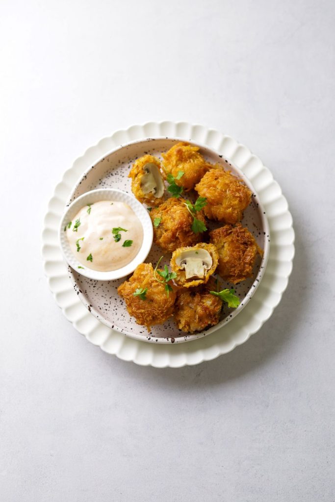 Egg-Free crumbed mushrooms in a white plate with a dip