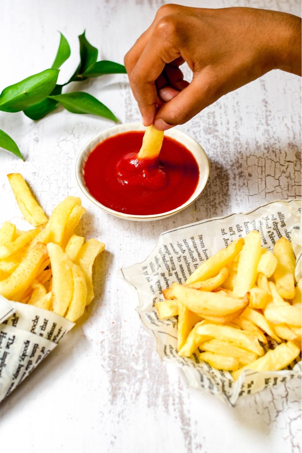 South African Slap Chips wrapped in newspaper with tomato sauce on the side