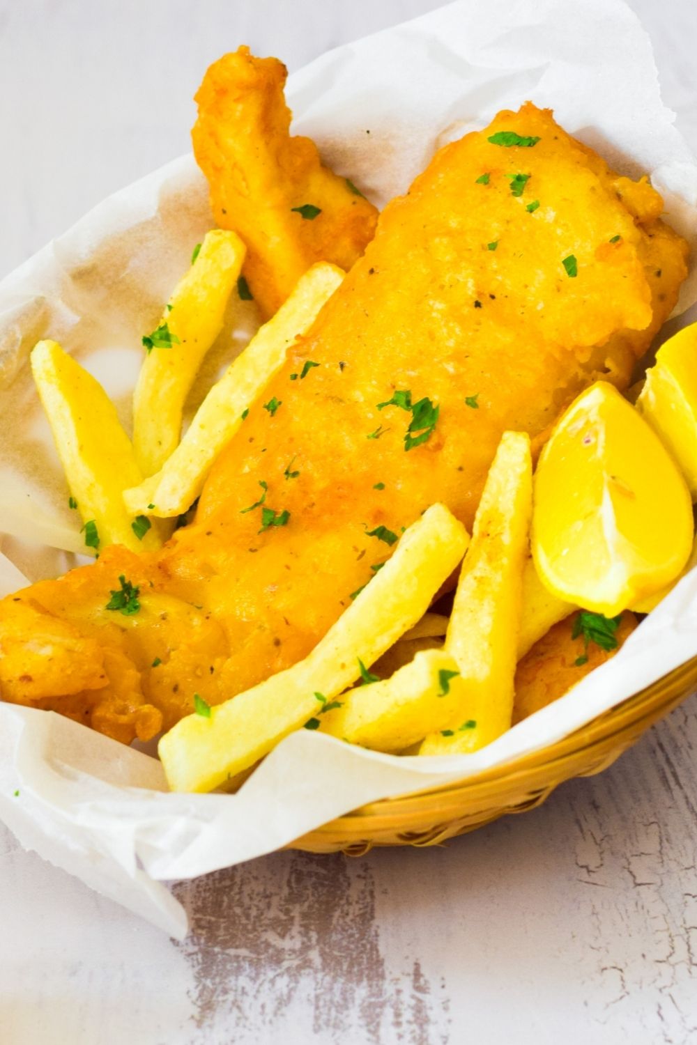 Crispy Battered Fish in a basket with chips and lemon