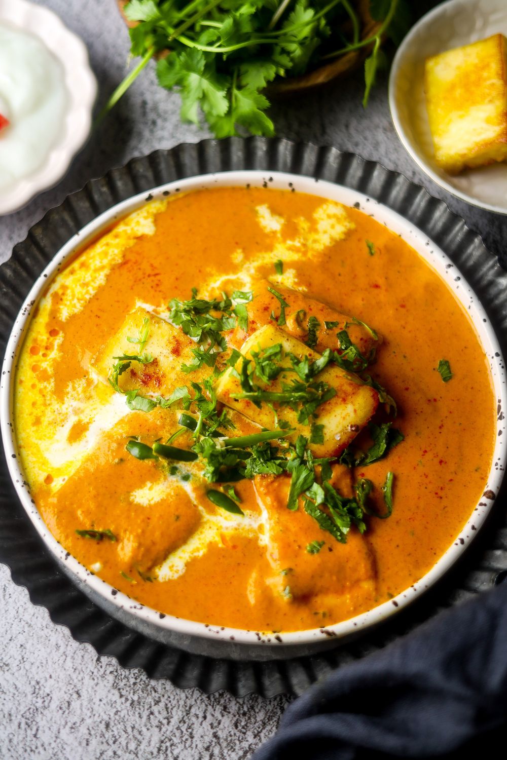 Butter paneer in a black and white bowl