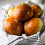 Brioche Buns in a dish with a kitchen towel