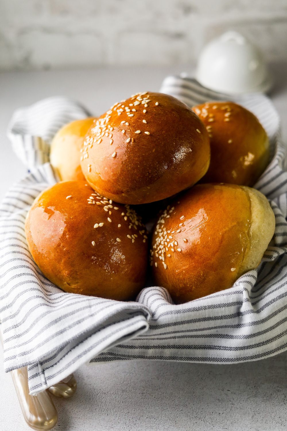 Brioche Buns in a dish with a kitchen towel