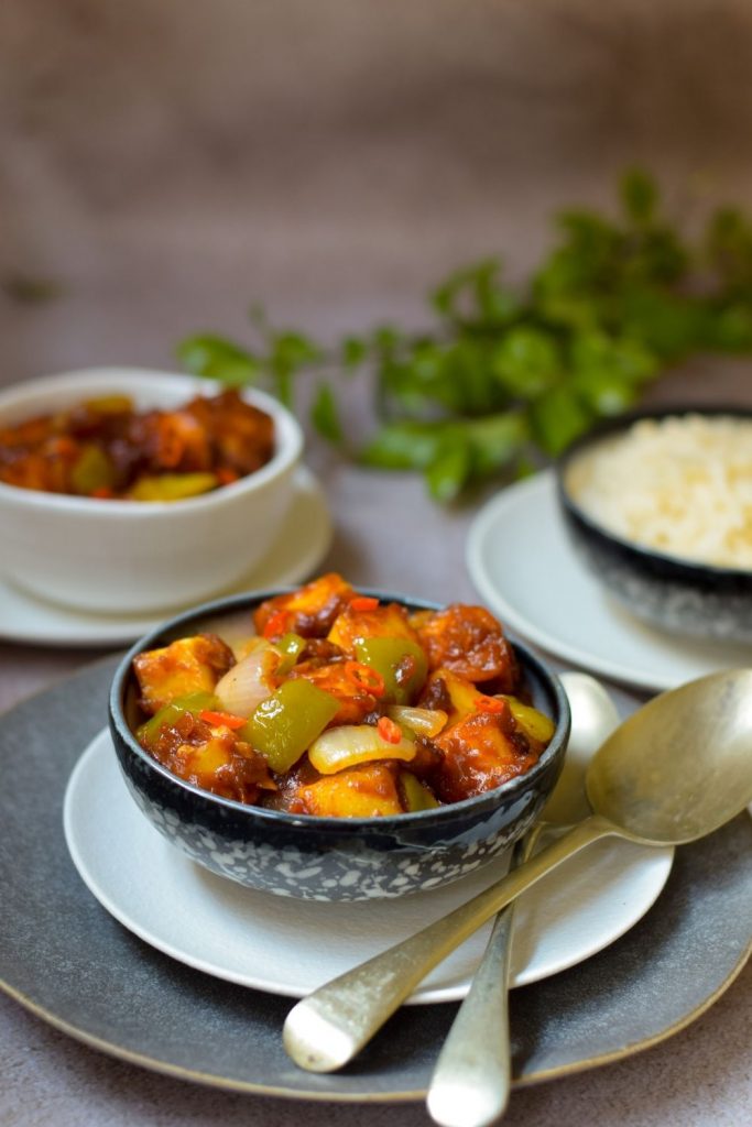 Chilli Paneer in two bowls with rice in one 