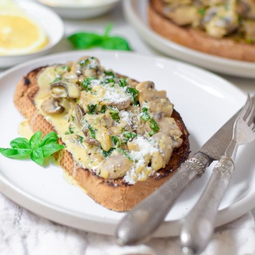 Creamy Basil Mushrooms on toast on a white plate