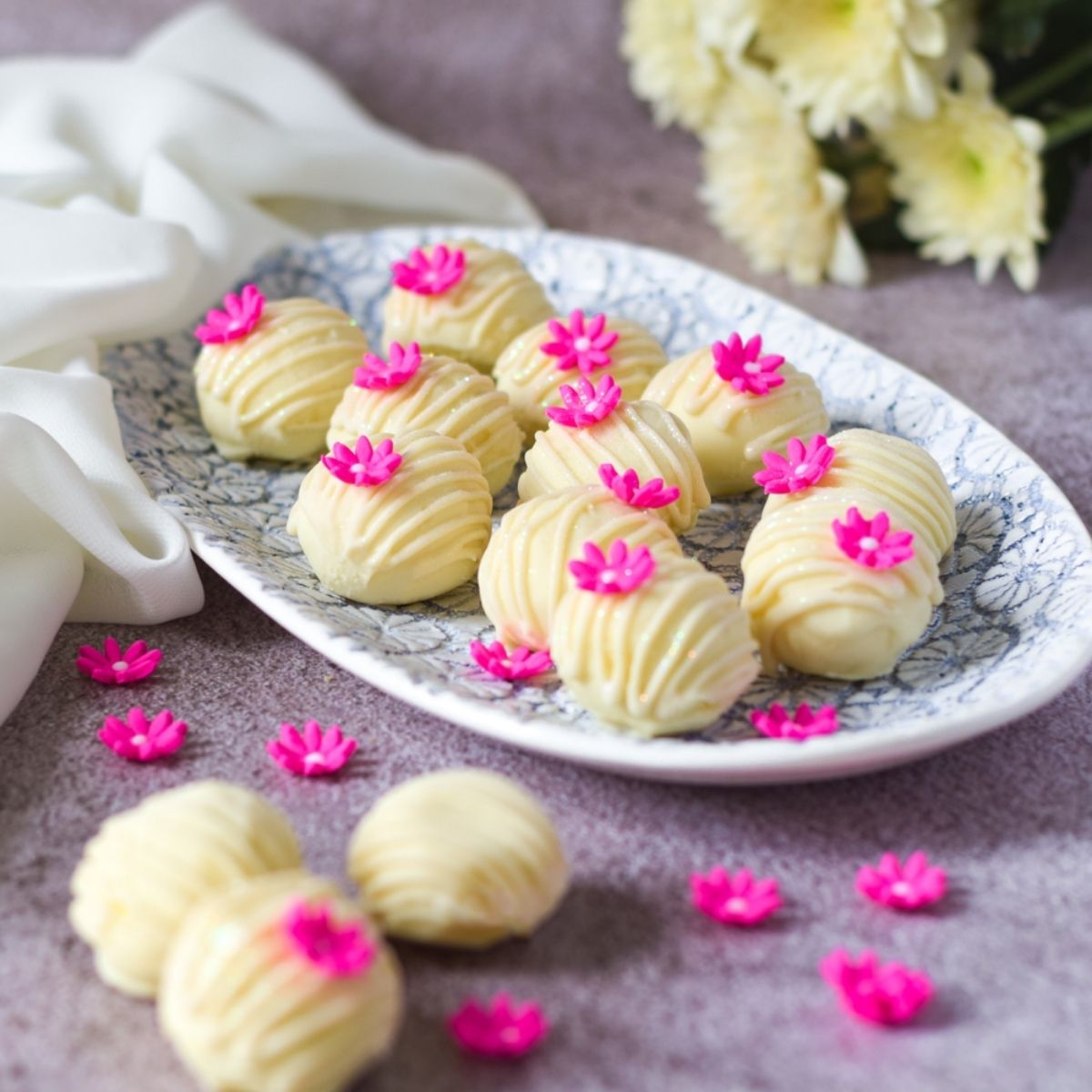 Penda Truffles on a platter with penda truffles on left, flowers at top right