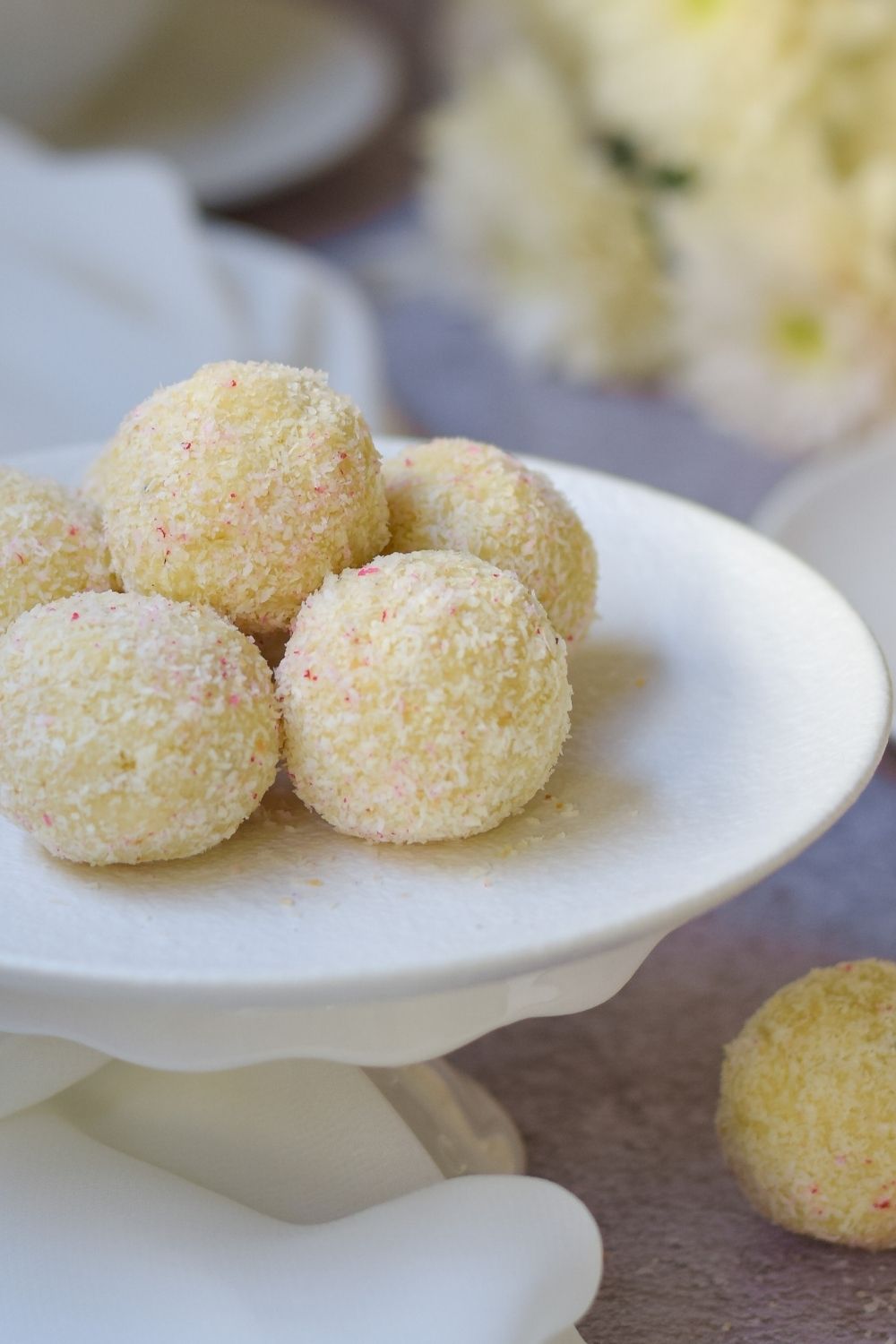 Soji Balls on a white cake stand with flowers at right back 