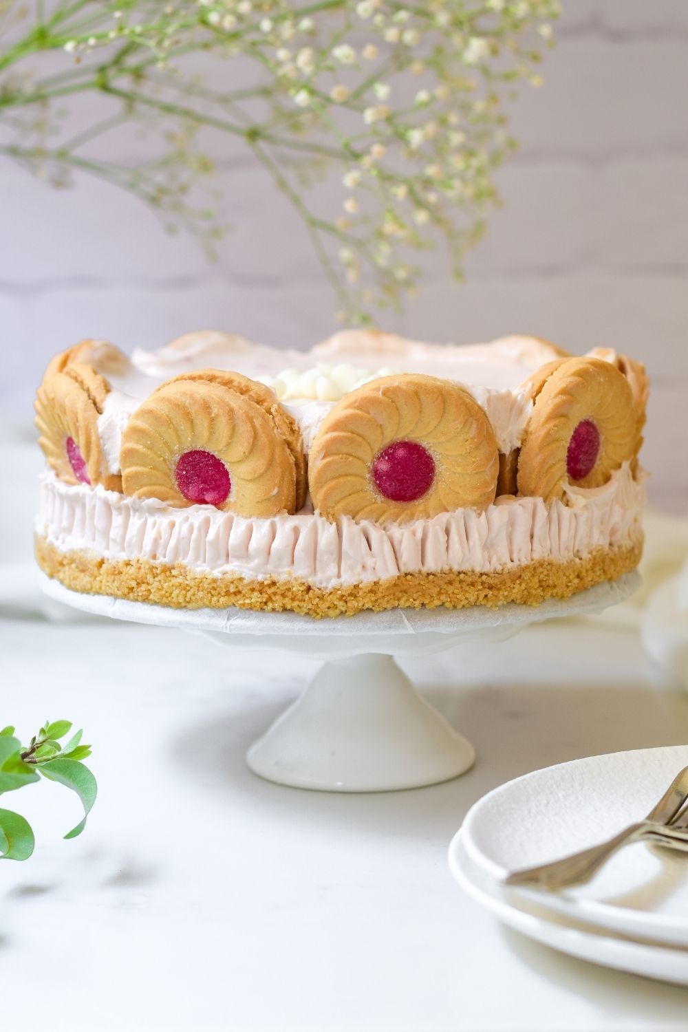 Strawberry Whirl Cheesecake on a white cake stand