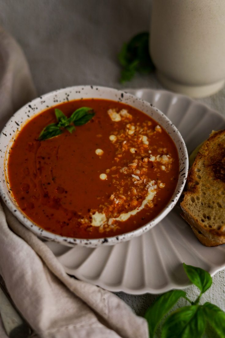 Roasted red pepper and tomato soup in a white bowl