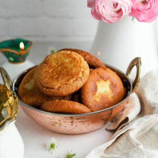 Roht in a copper bowl with flowers on right and lamp on left