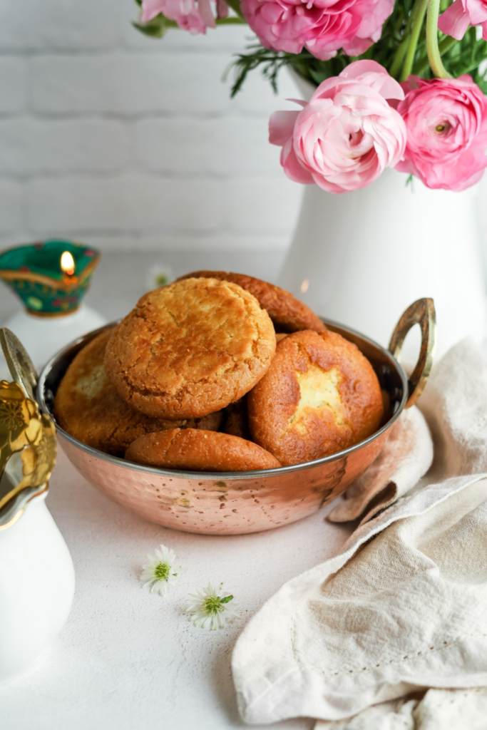 Roht in a copper bowl with flowers on right and lamp on left