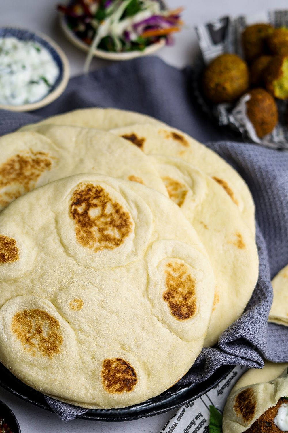 Pita Bread on a kitchen towel with falafel and salad on top