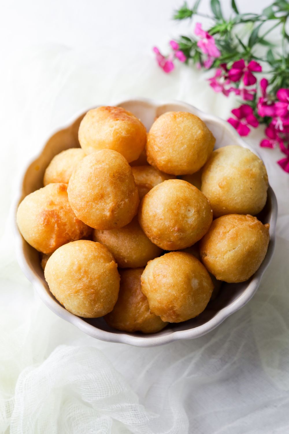 Gulgula in a white bowl with pink flowers at the top right