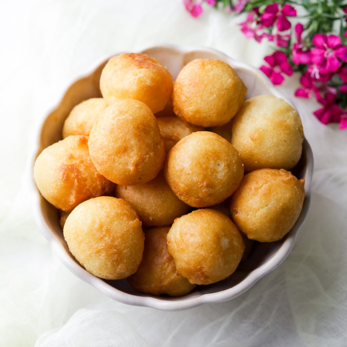 Gulgula in a white bowl with pink flowers at the top right