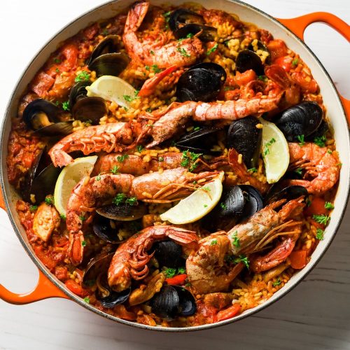 Paella in an orange and white pot